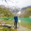 woman standing in front of body of water and mountain